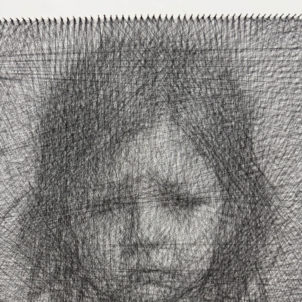 Detail of the Stop War string art showing thread and nail work